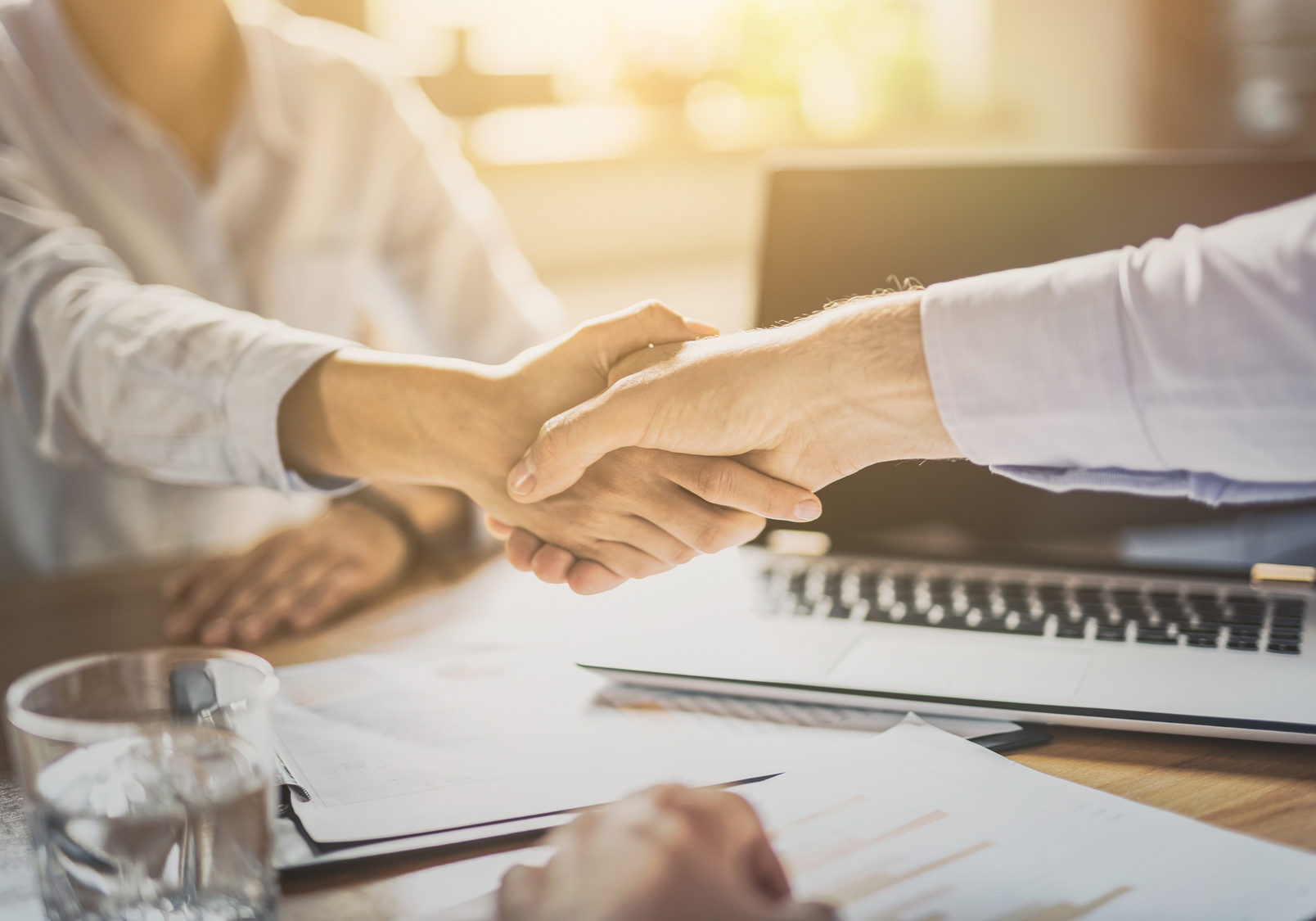 Business people shaking hands, finishing up meeting. Successful businessmen handshaking after good deal.